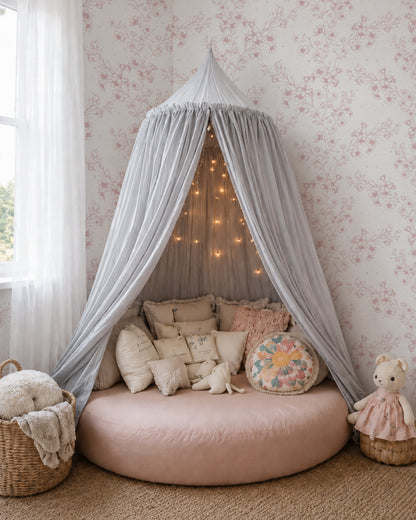 Blossom Whisper Dusty Rose floral wallpaper in a cozy canopy nook with layered cream and blush cushions.