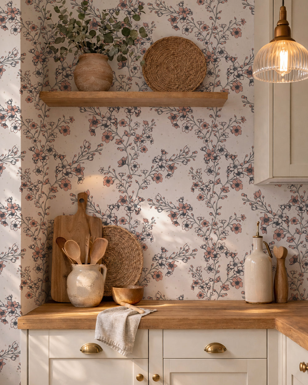 Blossom Whisper Peach floral wallpaper in a warm kitchen with wood counters, cream cabinetry and natural decor.