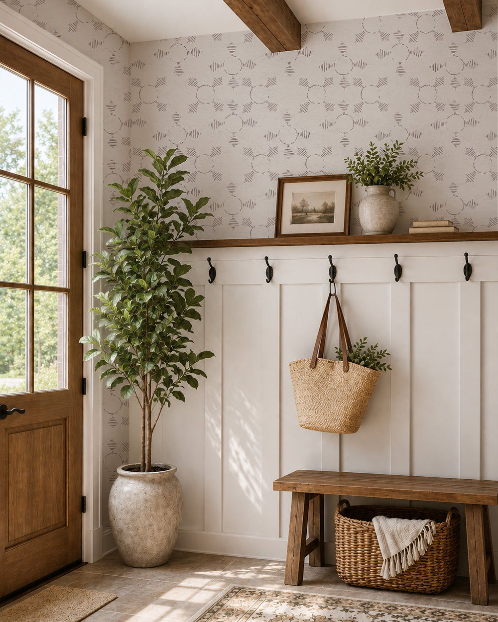 Boho Weave Soft Brown wallpaper in a warm entryway with white paneling, a wood bench and leafy plants.