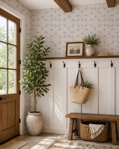 Boho Weave Soft Brown wallpaper in a warm entryway with white paneling, a wood bench and leafy plants.