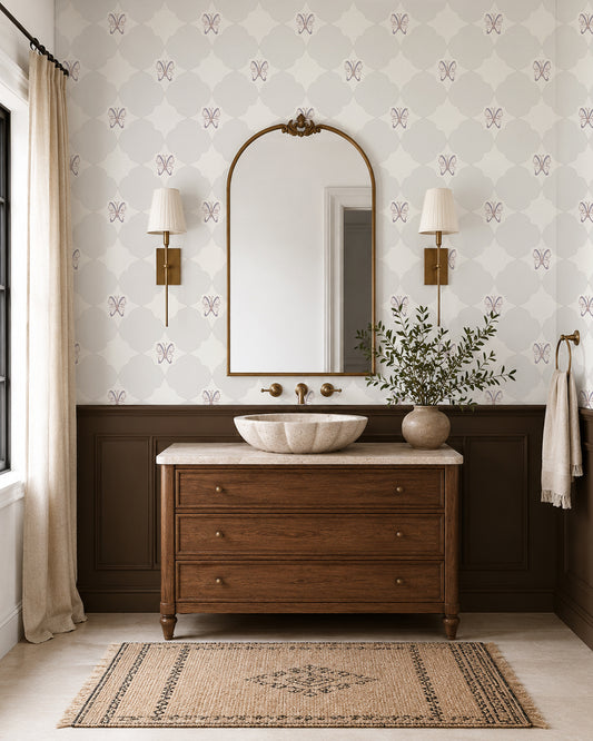 Keepsake Linen wallpaper in an elegant bathroom with a wood vanity, dark wainscoting and brass sconces.