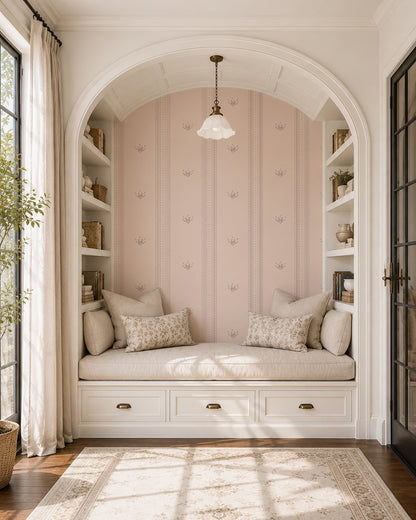 Lace Garden Blush wallpaper in a cozy reading nook with built-in shelves, cream cushions and soft natural light.
