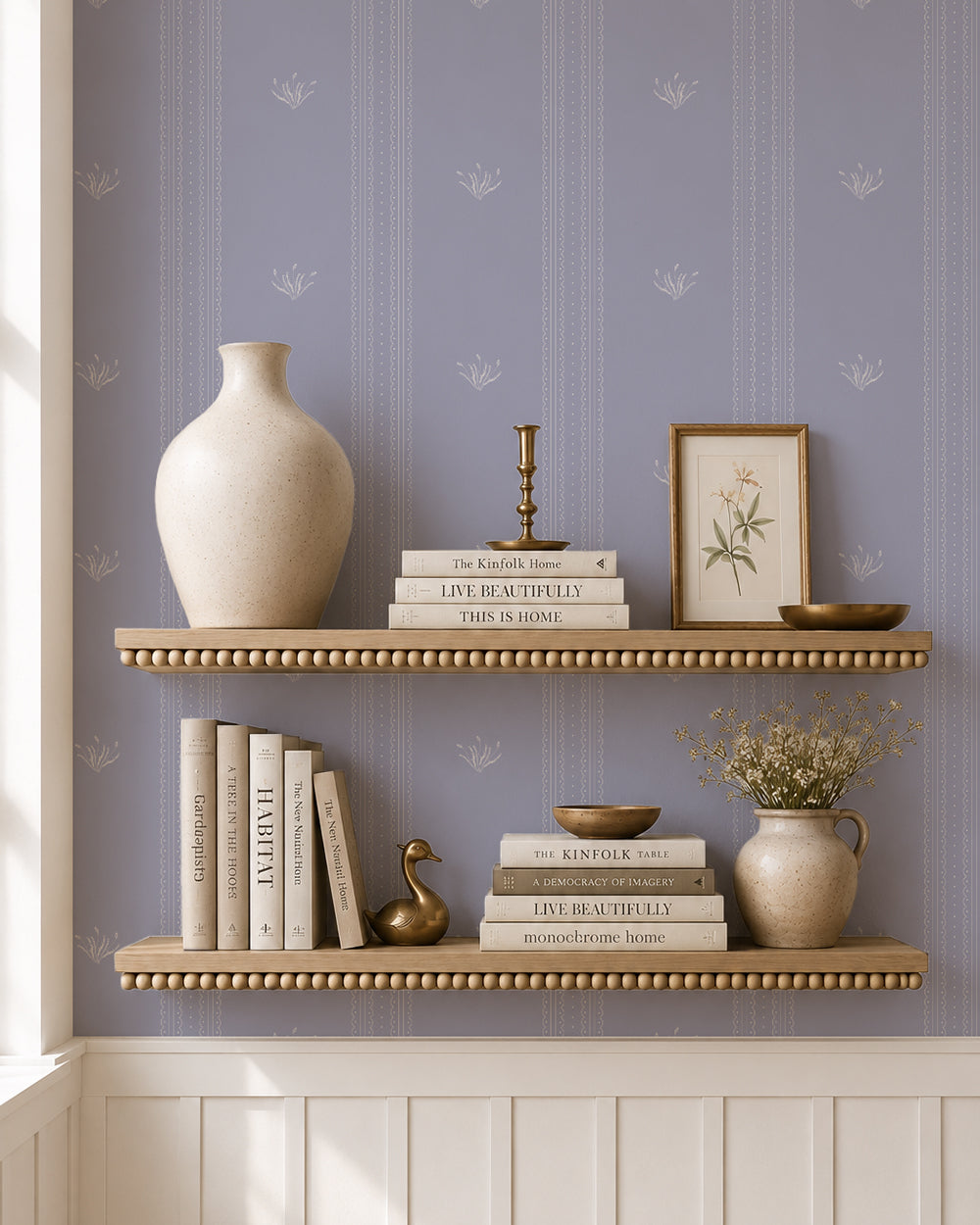 Lace Garden Country Blue wallpaper behind styled shelves with books, pottery and warm brass accents.
