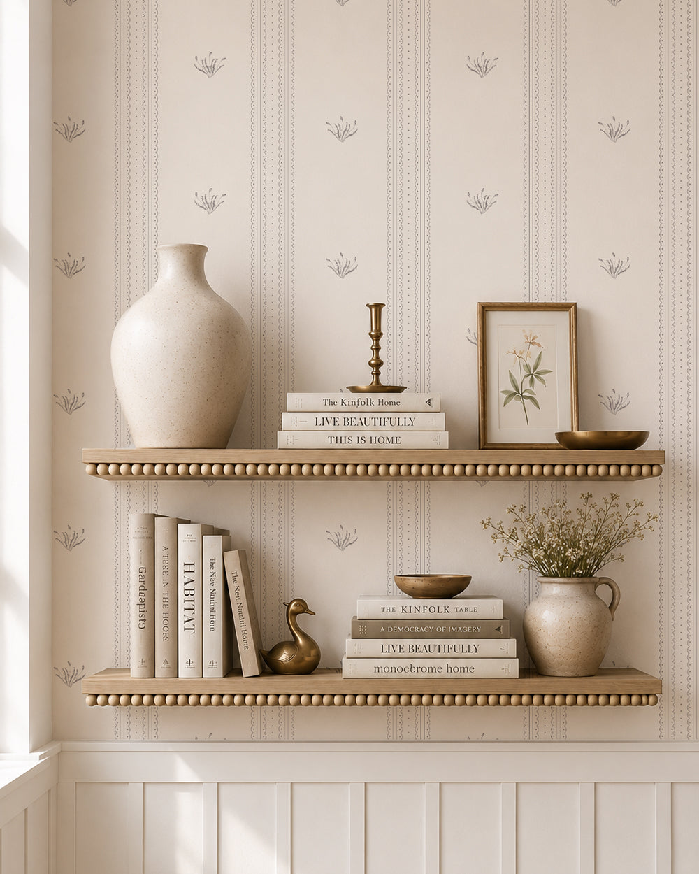 Lace Garden Warm Brown wallpaper behind styled shelves with books, pottery and warm brass accents.