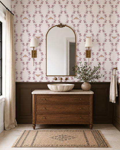 Night Bloom Soft Blush wallpaper in an elegant bathroom with dark wood vanity, brass accents and cream wainscoting.