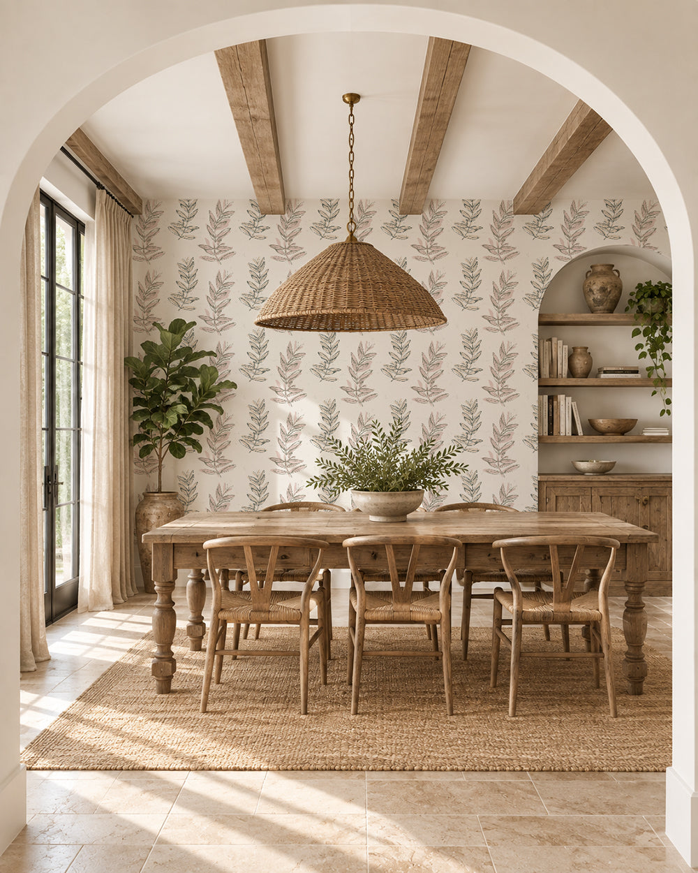Olive Branch Olive wallpaper in a warm dining room with wood furniture, woven lighting and leafy plants.