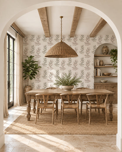 Olive Branch Olive wallpaper in a warm dining room with wood furniture, woven lighting and leafy plants.
