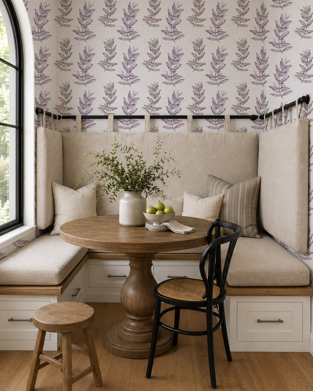 Olive Branch Plum wallpaper in a cozy breakfast nook with built-in seating, a round wood table and neutral accents.