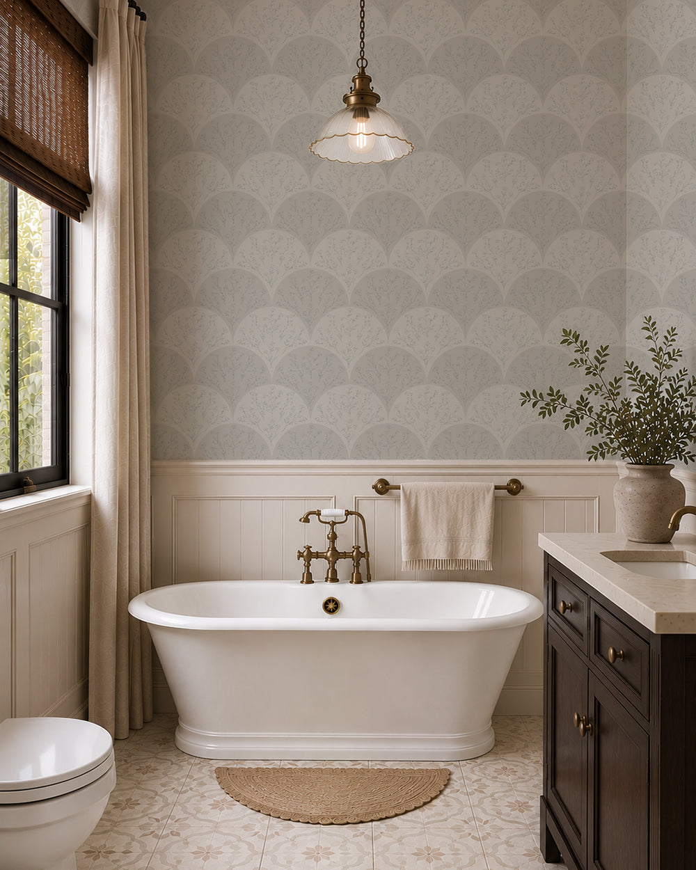 Soft sage floral fan wallpaper in an elegant bathroom with a freestanding tub, brass fixtures and sage vanity.