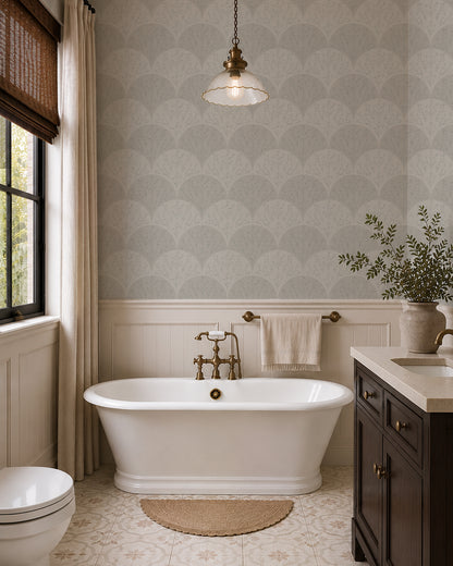 Soft sage floral fan wallpaper in an elegant bathroom with a freestanding tub, brass fixtures and sage vanity.