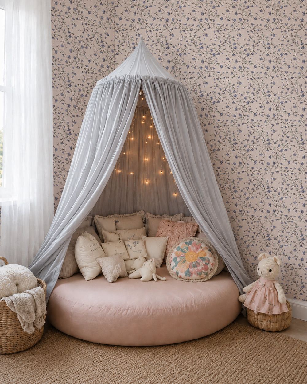 Spring Vine Bluebell Blush wallpaper in a cozy canopy nook with layered cream cushions, soft blush accents and warm lighting.