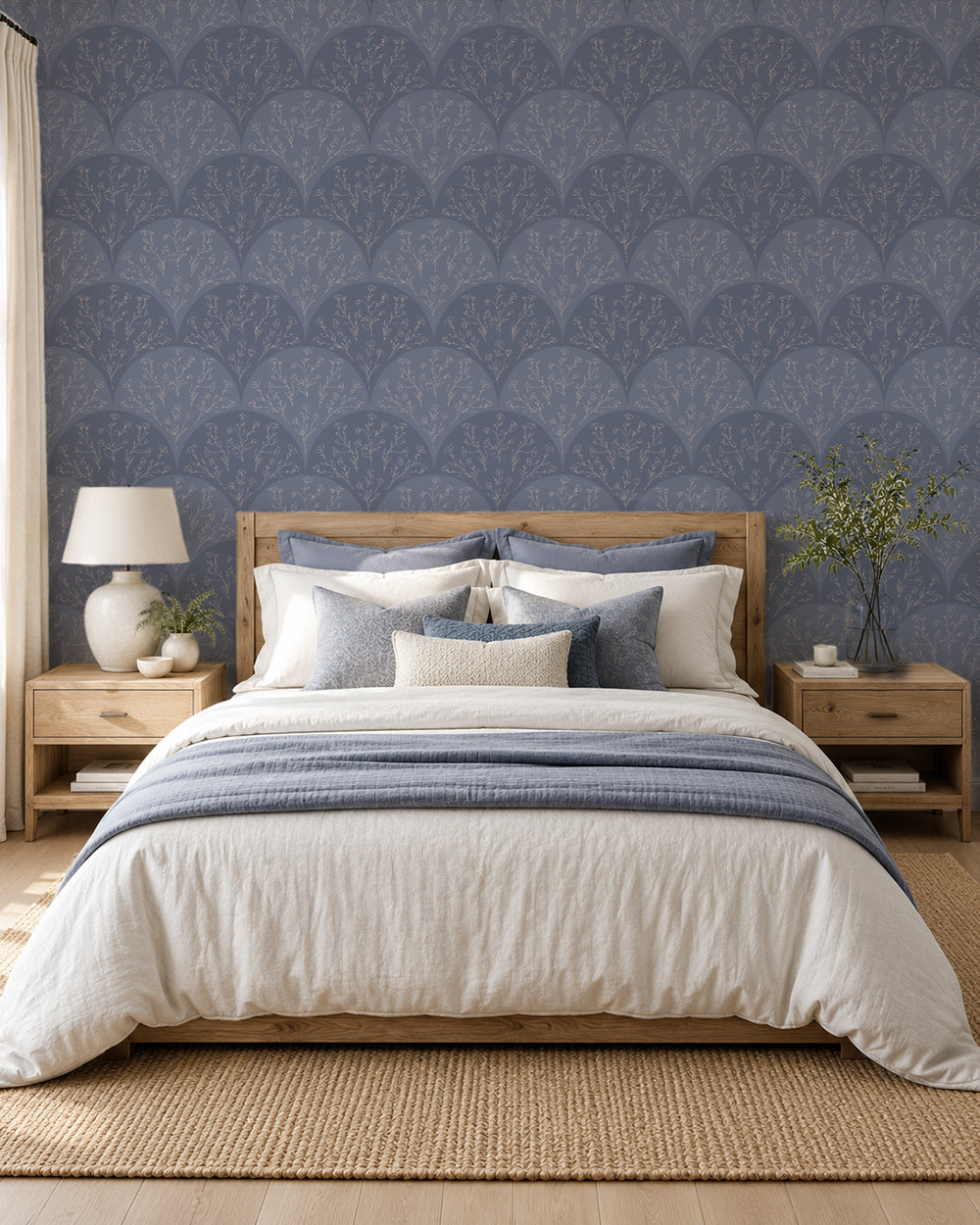 Stitched Meadow Dusty Blue wallpaper in a serene bedroom with light wood furniture and layered neutral bedding.