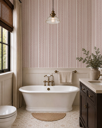 Ticking Stripe Soft Blush wallpaper in a bright bathroom with a freestanding tub, dark wood vanity and cream paneling.