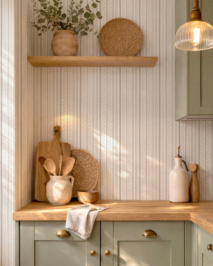 Ticking Stripe Soft Taupe on Cream wallpaper in a warm kitchen with wood accents, cream pottery and natural light.